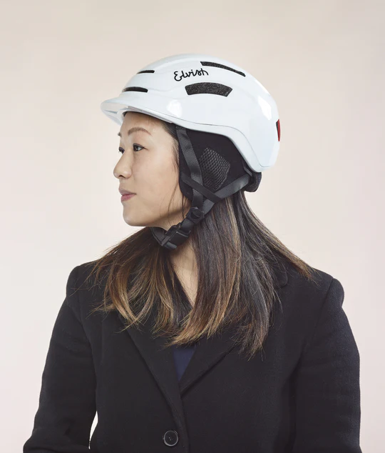 Casque - Vélotaffeur casque Elvish blanc porté par un mannequin insert LED arrière offre une visibilité maximale pour les autres usagers. Pratique et rapide, fermeture et ouverture instantanément de la boucle d'attache grâce à son système aimanté. vue de côté blanc porté par un mannequin